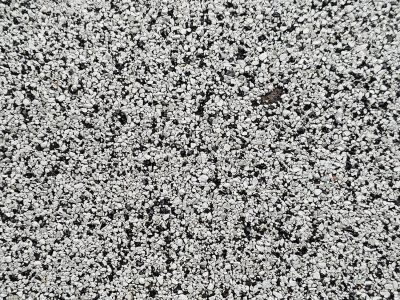 Grey pits meet the light, jagged scars trace the surface, grit holds the pattern