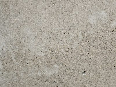 Grey stone holds its form, tiny pits mark out the space, cold and solid wall