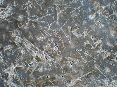 Grey stone holds the mark, carved pride etched in deep relief, weathered surface scars