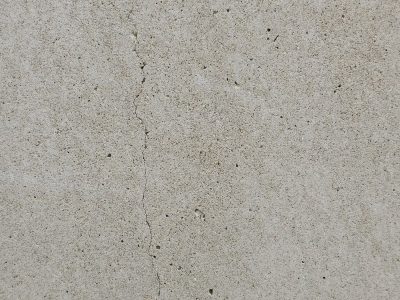 Grey wall is quiet, jagged line cuts through the face, silent stress remains