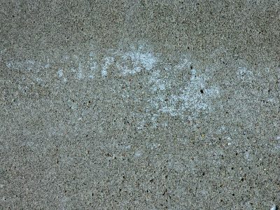 Grey wall weeps in rain, vertical stains mark the time, concrete breathes in salt