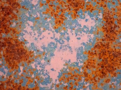 Heart of blue meets light, orange grit claims the metal, years leave a deep trace