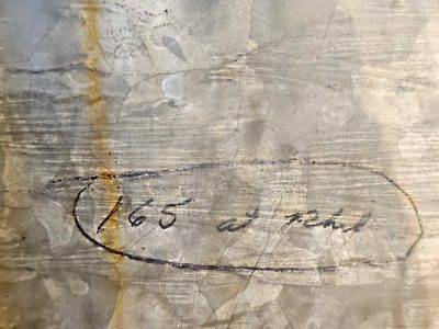 Ink marks on cold steel, rust runs down the metal plate, numbers tell a tale