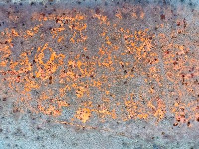 Maroon fields meet grey, jagged lines trace the surface, light holds the pattern