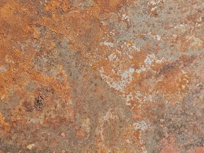 Orange fields meet grey, jagged rust traces paths, light holds the pattern