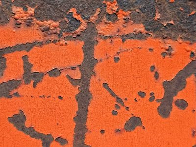 Orange skin peels back, iron yields to deep brown rust, cracked lines form a map