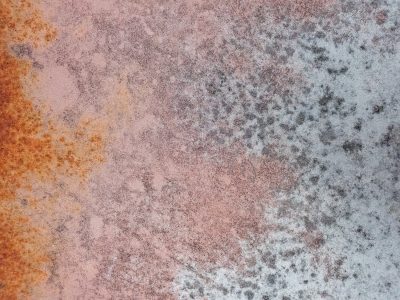 Orange stains the rock, ancient stone turns dusty pink, grey shadows scatter
