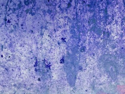 Orange strips lift up, mottled grey meets the light, grit marks the metal finish