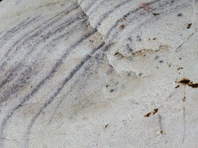 Pale grains flow in lines, horizontal veins hold light, time carves the pattern