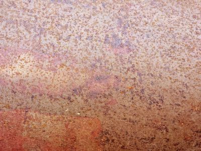 Pink mist holds the field, orange grit claims the metal, years leave a deep trace