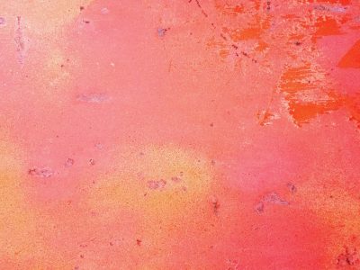 Pink paint wears away, orange layers glow beneath, textured surface scars