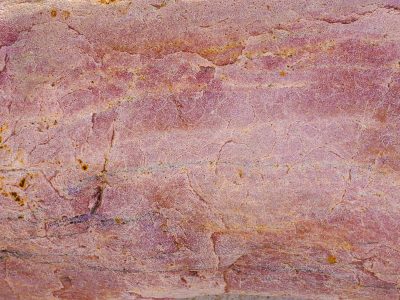 Pink veins cross the ridge, dusty hues of ancient stone, layers carved by years
