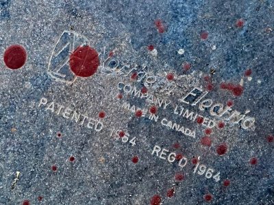 Raised type on cold blue, scarlet paint spatters the steel, sixty four remains