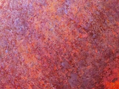 Red iron decays, purple stains the textured plate, metal turns to dust