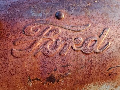 Red oxidation, metal script reveals the name, iron pits with age