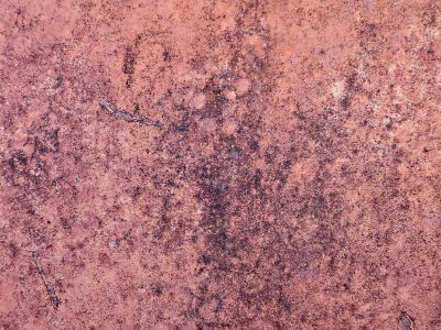 Red oxidation, mottled surface scarred by time, iron starts to fade