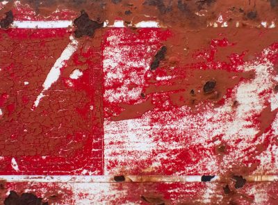 Red paint flakes away, iron yields to creeping rust, time eats through the sign