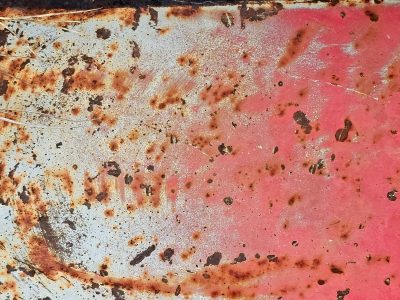 Red paint flakes away, iron yields to orange rust, surface turns to dust