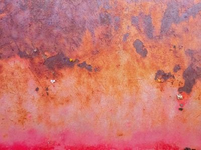 Red paint flakes away, rust blooms through the iron skin, time wears down the steel