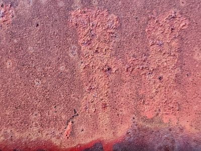 Red rust flakes away, orange grit on ancient steel, metal turns to dust