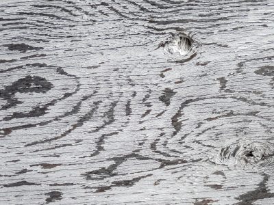 Red skin fades to grey, vertical lines trace the field, grit holds the center