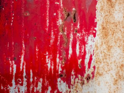 Crimson streaks descend, orange rust eats through the grey, metal wears away