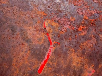 Red streaks haunt the field, dark grit claims the heavy surface, time marks the metal