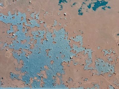 Rose skin peels away, teal depths reveal silent scars, weathered layers fade