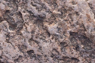 Rough peaks of grey stone, dark shadows hide in deep pits, forged in heat and time