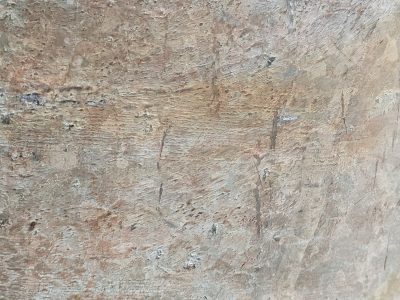 Rough stone holds the dust, scratches mark the silent face, earth tones fade away