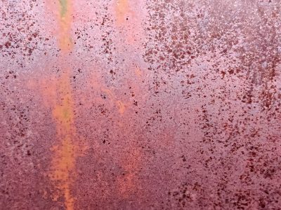 Rust blooms on the steel, pitted surface tells the tale, iron turns to dust