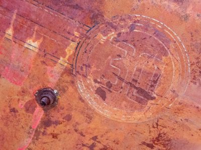 Rusty thirty stays, orange grit claims the metal, time marks the heavy