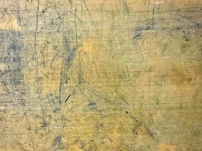 Scratches cross the gold, deep lines mark the weathered face, time etched in the grain