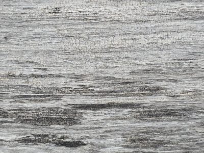 Silver wood grain fades, time etches horizontal paths, aged texture remains