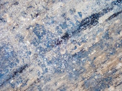 Stains of blue and grey, weathered ground holds dusty grit, rough paths mark the way