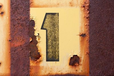 Stenciled number one, orange rust eats through the paint, metal yields to time