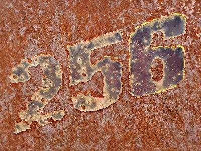 Stenciled numbers meet the rust, heavy grit claims the surface, time leaves a deep mark