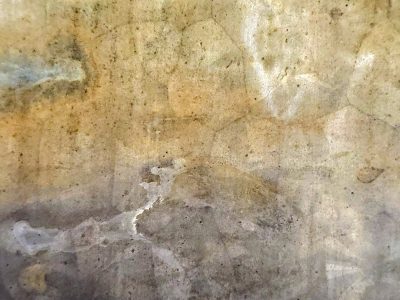 Tan mist holds the light, mottled spots trace the heavy metal, grit marks the finish