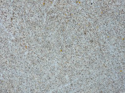 Tan skin has deep paths, jagged scars trace the heavy stone, light carves the surface