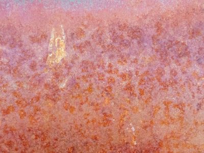 Teal mist holds the field, vertical streaks trace the skin, light catches the grit