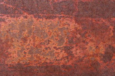 Thick rust eats the steel, orange dust coats the surface, metal flakes away