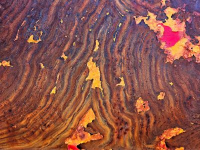 Wavy lines of rust, orange grit claims the surface, time leaves a deep mark