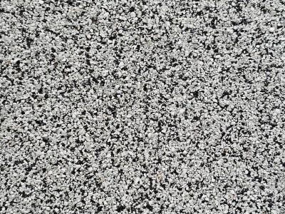 White grit on the road, scattered patterns in the dark, rough path waits below