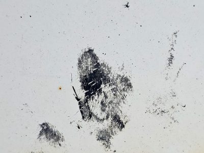 White paint fades away, dark scars mar the empty space, metal shows its age