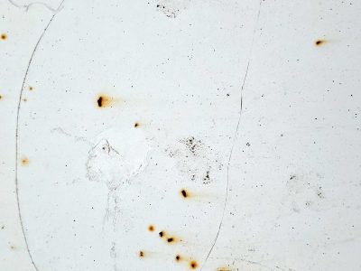 White paint starts to crack, orange rust bleeds through the skin, metal shows its age