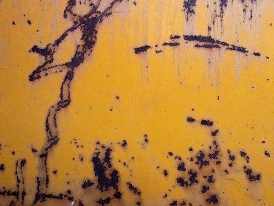 Yellow fields meet dark, jagged spots trace the surface, grit holds the finish