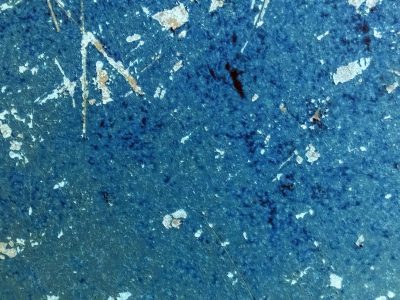 Blue paint peels away, white flecks dance on weathered steel, time scars the surface