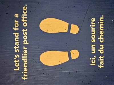 Yellow footprints wait, friendly words on scuffed up blue, patience marks the spot