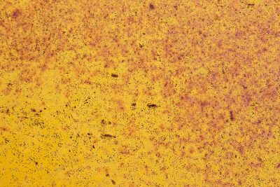 Yellow paint decays, iron oxide blooms on steel, time eats through the coat