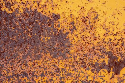 Yellow paint yields ground, brown oxidation spreads out, rust claims every inch